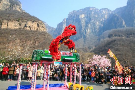 游人在河南云台山景区观看民俗舞狮表演。