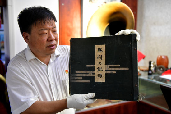 图为张建洛展示自己收藏的黑胶唱片 受访者供图