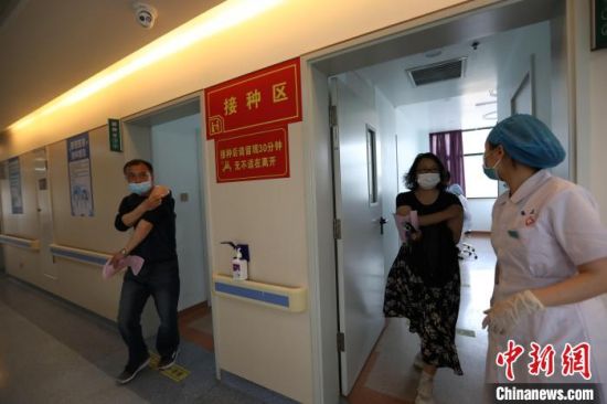 图为郑州市民接种完新冠疫苗走出接种室 阚力 摄