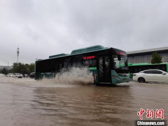 图为7月20日上午，郑州市区，公交车从积水的道路驶过。　李贵刚 摄
