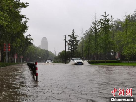 图为7月20日上午，郑州市区，汽车在积水的道路行驶。　李贵刚 摄