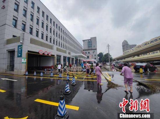 图为7月22日，郑州大学第一附属医院河医院区门诊大楼前铺满排水管道，向外排水。阚力 摄