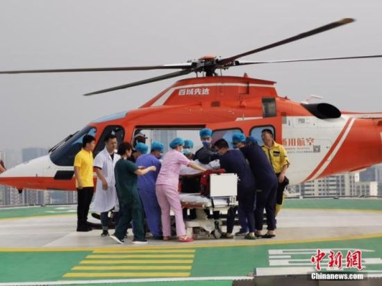　7月22日，受灾严重的郑州市阜外华中心血管病医院通过直升机、冲锋舟、皮划艇向外转运患者。图为医护人员将一名危重病患婴儿送上直升机进行转移。 中新社发 王登峰 摄