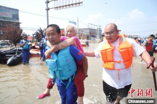 救援人员背着老人进行转移。　鲍晓峰 摄