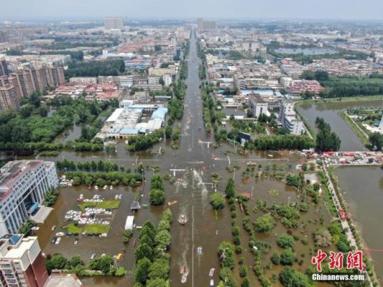 　7月26日，河南省卫辉市城区部分路段尚有积水，多支救援力量在当地展开救援工作。中新社记者 崔楠 摄