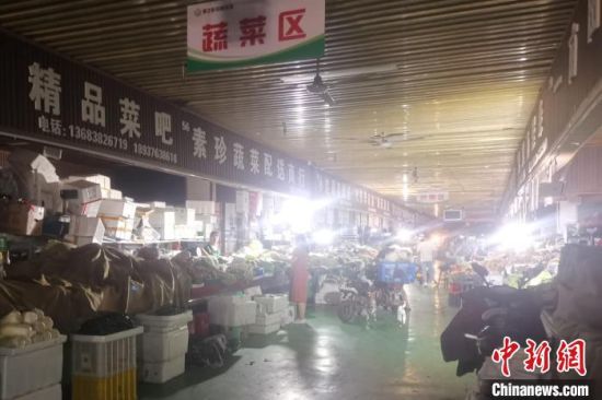图为郑州市某农贸市场因电力方面仍在抢修，内部光线相较以往显得昏暗，但却丝毫不影响市民选购生活用品。　李明明 摄