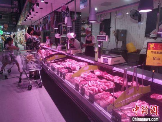 图为郑州市某超市内，生鲜肉类摊位前，市民正在选购，并且货源充足。　李明明 摄