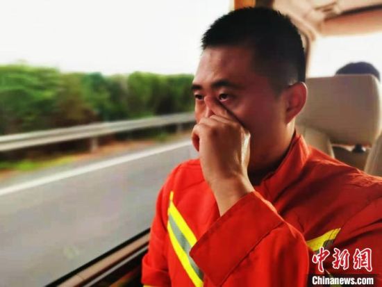 　车队驶入高速公路，一名消防员抹掉泪水。他说，永远难忘汝阳人民的热情。　陆祁国 摄