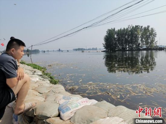  面对傅庄堤南侧的无边洪水，一名男子表情凝重。　陆祁国 摄
