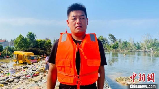 王浩明身后的堤坝，见证了他的汗水和泪水。　受访者供图