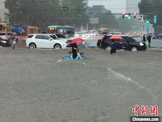 　图为7月20日郑州遭遇罕见强降水，市民涉水前行。(资料图) 韩章云 摄
