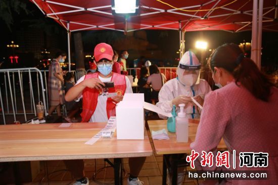 图为志愿者在全员核酸检测现场提供志愿服务。 新郑市委统战部供图