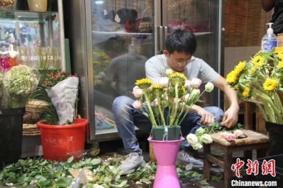 　图为一名男子正在插花做花束。　李明明 摄