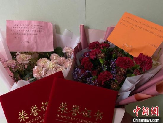 图为“摆渡女孩”们收到的鲜花感、感谢信以及荣誉证书。　刘梦珂 摄
