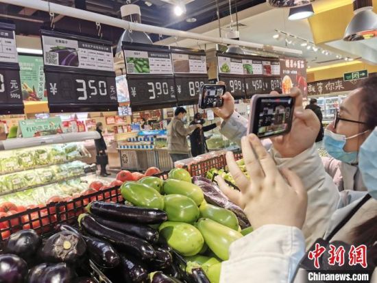图为消费者在河南省鹤壁市淇滨区一家超市内扫码获取农产品信息。　韩章云 摄