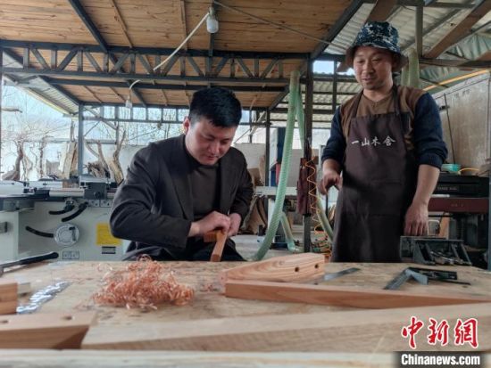 　图为爱好者在王耀斌的指导下做木工。　阚力 摄