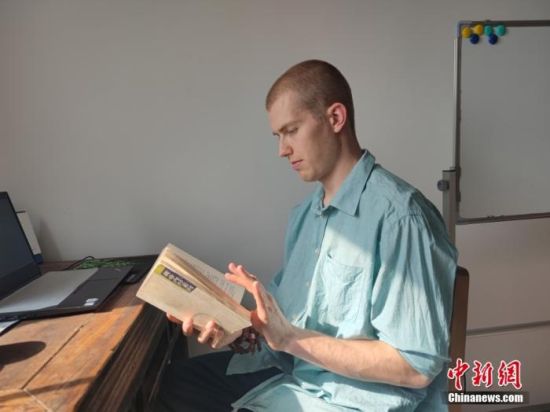 图为4月20日，无名在郑州家中翻阅《黄帝内经》。 中新社记者 阚力 摄