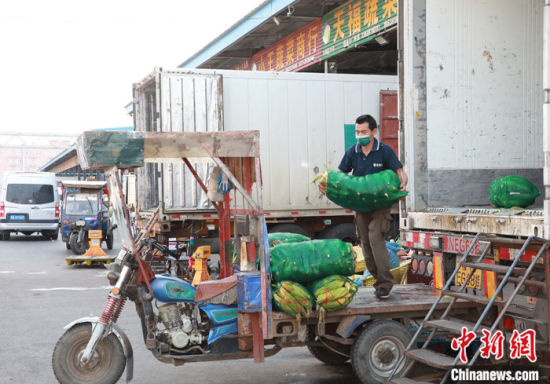 图为5月5日，工作人员在有“菜篮子”之称的河南万邦国际农产品物流城忙碌。 中新社记者 阚力 摄