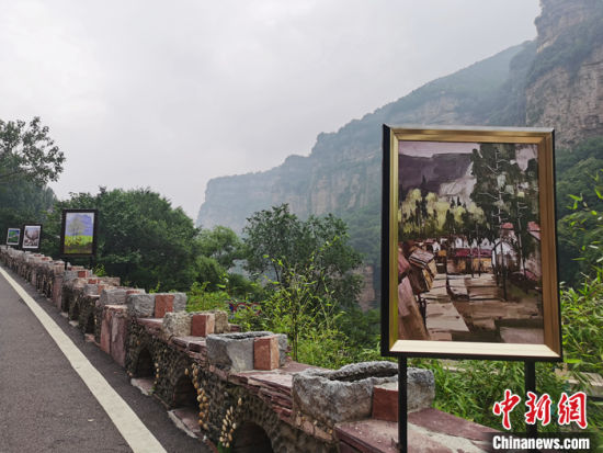 图为7月27日，石板岩镇盘山公路边展出的“石板岩校友作品”。中新社记者 刘鹏 摄