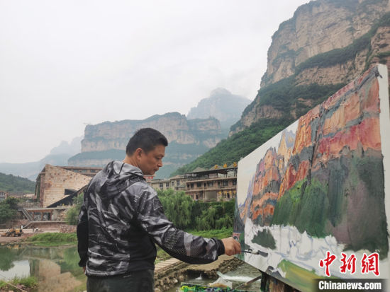 图为7月27日，天津美术学院油画系主任袁文彬在石板岩作画。中新社记者 刘鹏 摄