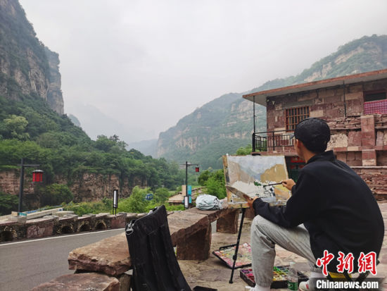 图为7月27日，一名学生在石板岩作画。中新社记者 刘鹏 摄