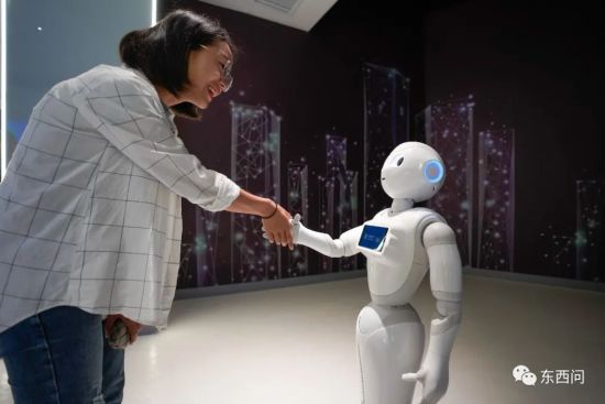 在��家大���（�F州）�C合���^展示中心，�⒂^者�c5G+智能�C器人“小5”握手。 中新社�l �R俊怡 �z
