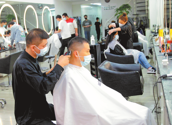 　11月2日，郑州市一家理发店，理发师正在为顾客理发。(记者 邓放 摄)