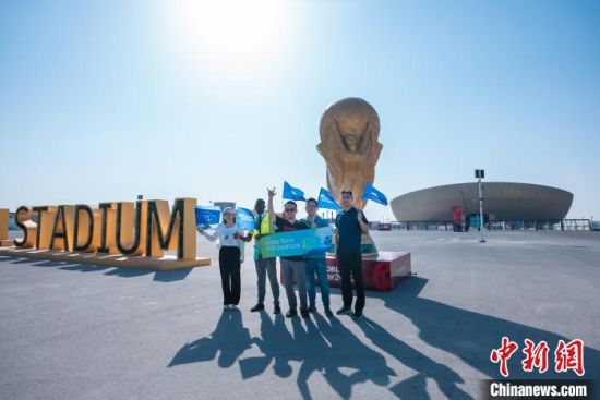 图为范艳涛(右二)和同事在2022卡塔尔世界杯主体育场卢赛尔体育场前合影。　受访者供图