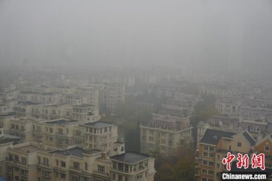 图为郑州城市建筑在雾中若隐若现。　刘鹏 摄