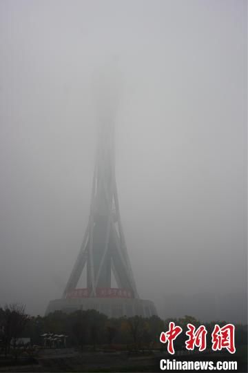图为郑州地标建筑“中原福塔”在雾中“隐身”。　刘鹏 摄