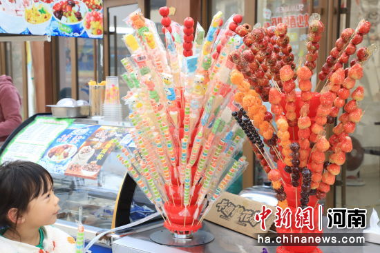 　河南范县，集市上的糖葫芦吸引小朋友驻足。冯丽苹 摄