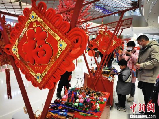 　春节假期期间，郑州一商场设置的传统手工摊位吸引消费者。　韩章云 摄