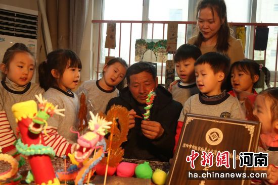 2月21日，在范县第一幼儿园美术馆内，孩子们向市级非遗传承人石延英学习“捏祥龙”。 张雯博 摄