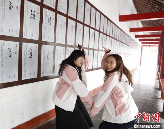 1月17日，台北商业大学的柯俐安和吴安琪在河南安阳殷墟遗址摆出甲骨文“向”字造型。　中新社记者 阚力 摄
