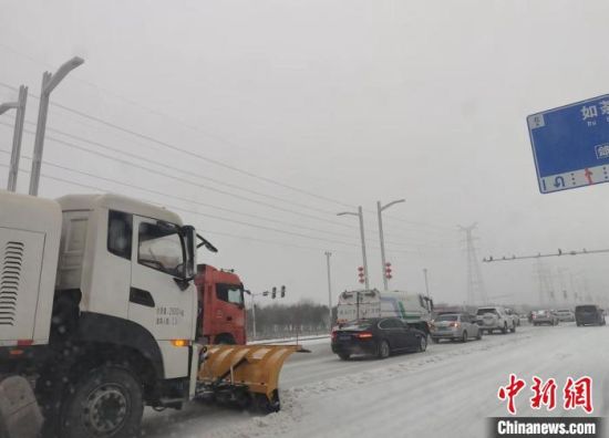 图为郑州航空港区除雪车辆在道路上除雪。 杨大勇 摄